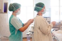 Nurses putting on sterile uniforms before surgery in Moscow, Russia. Health workers are highly exposed to risks in hospital environments.